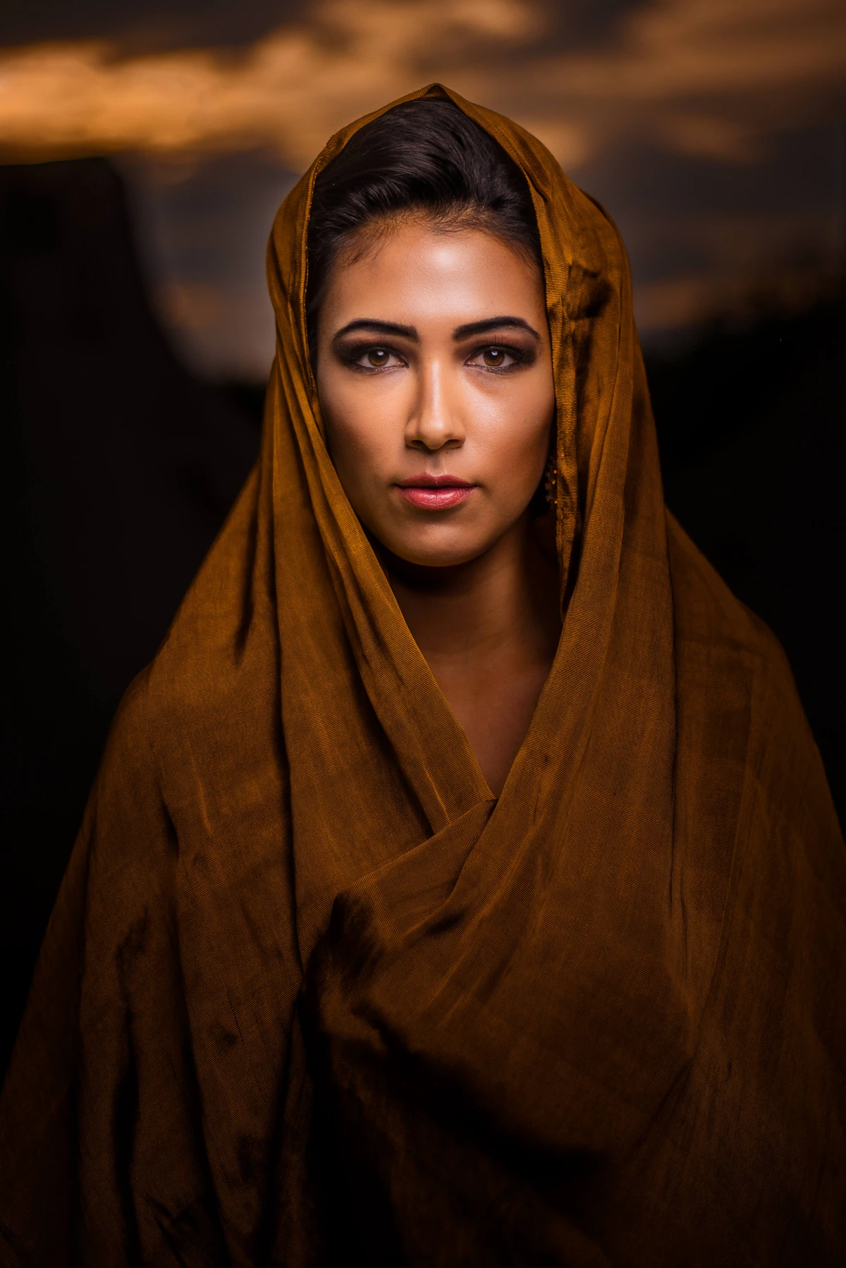 Woman wearing a moody, richly toned silk headscarf
