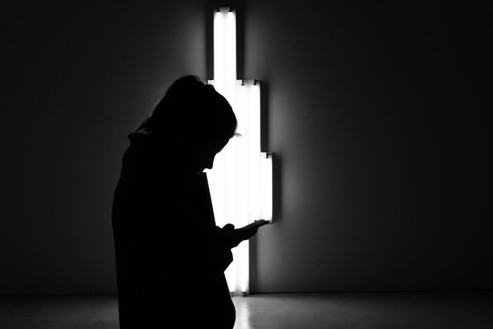 silhouette of person holding smartphone