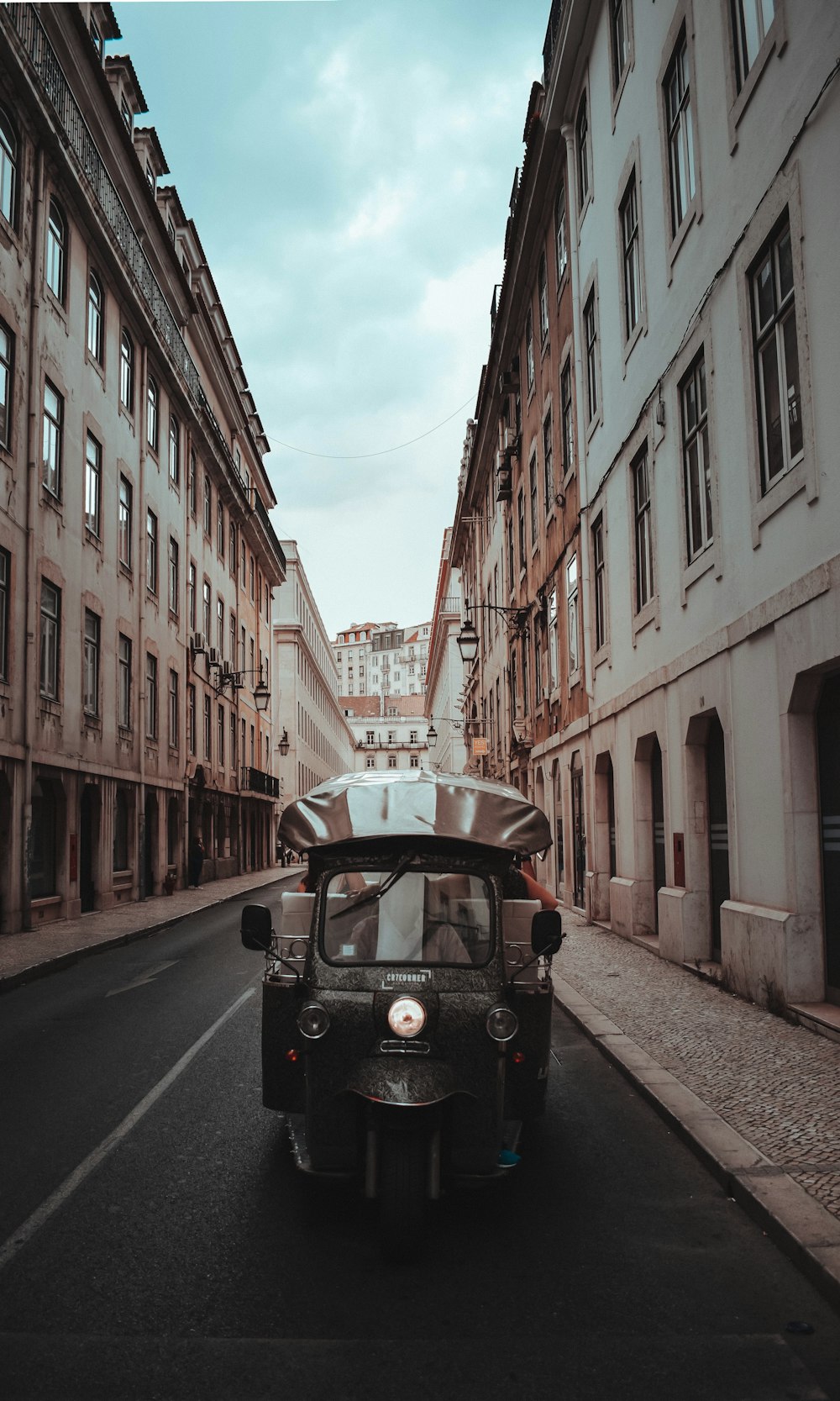 black auto rickshaw between buildings