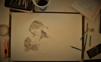 An artist sketching a romantic scene on a drawing pad.