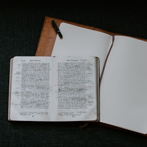 hardbound book on top of brown binder