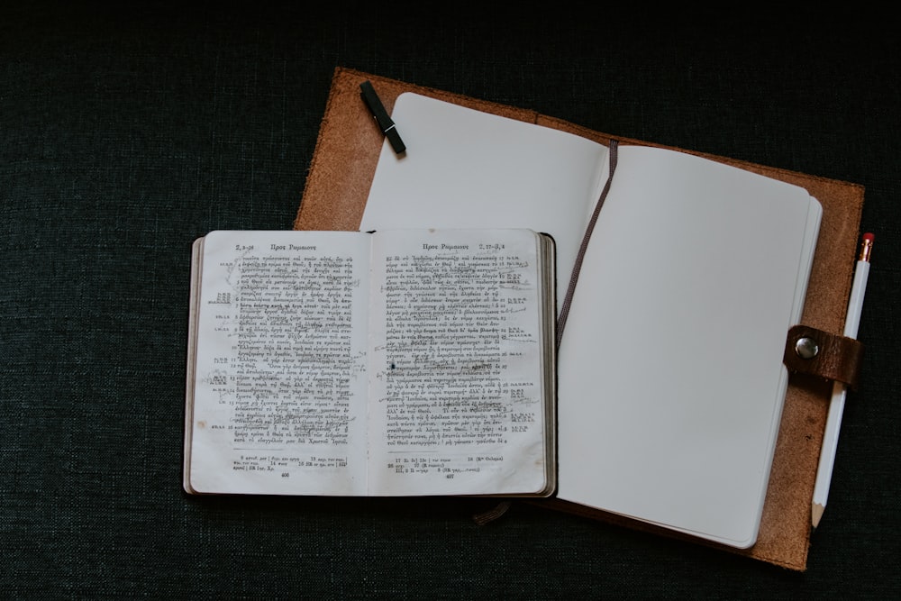 hardbound book on top of brown binder