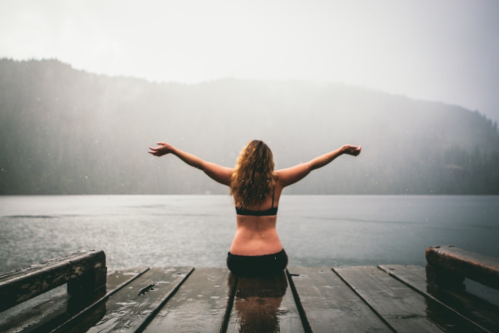 woman sitting on wooden dock