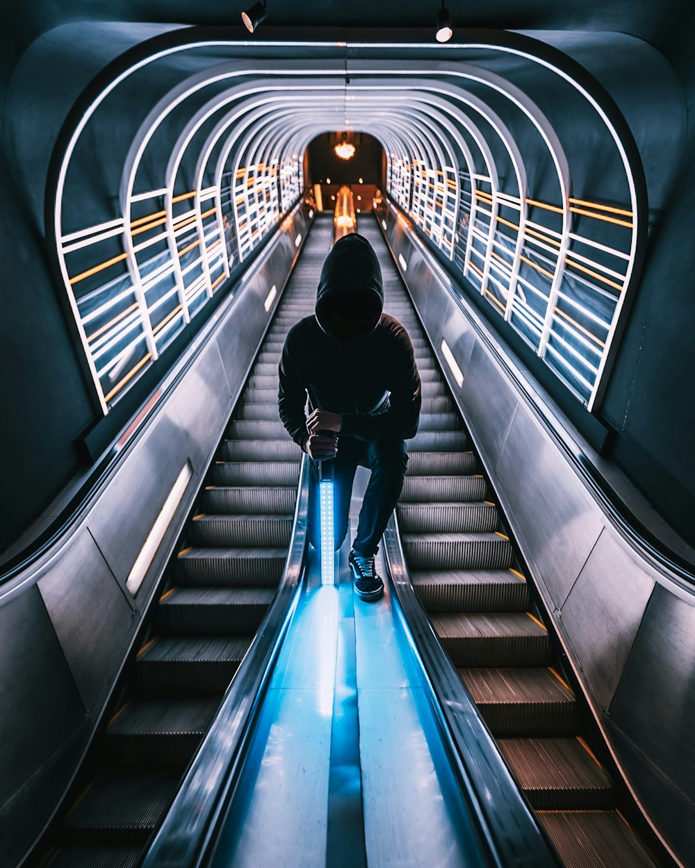 Persona parada entre las escaleras mecánicas