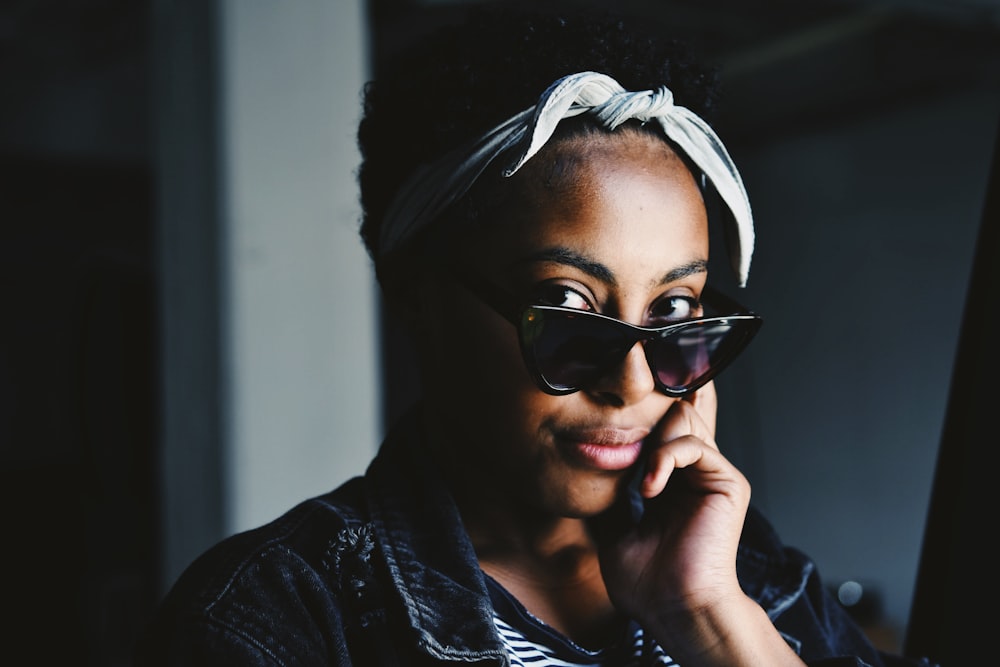 woman wearing sunglasses inside white painted room