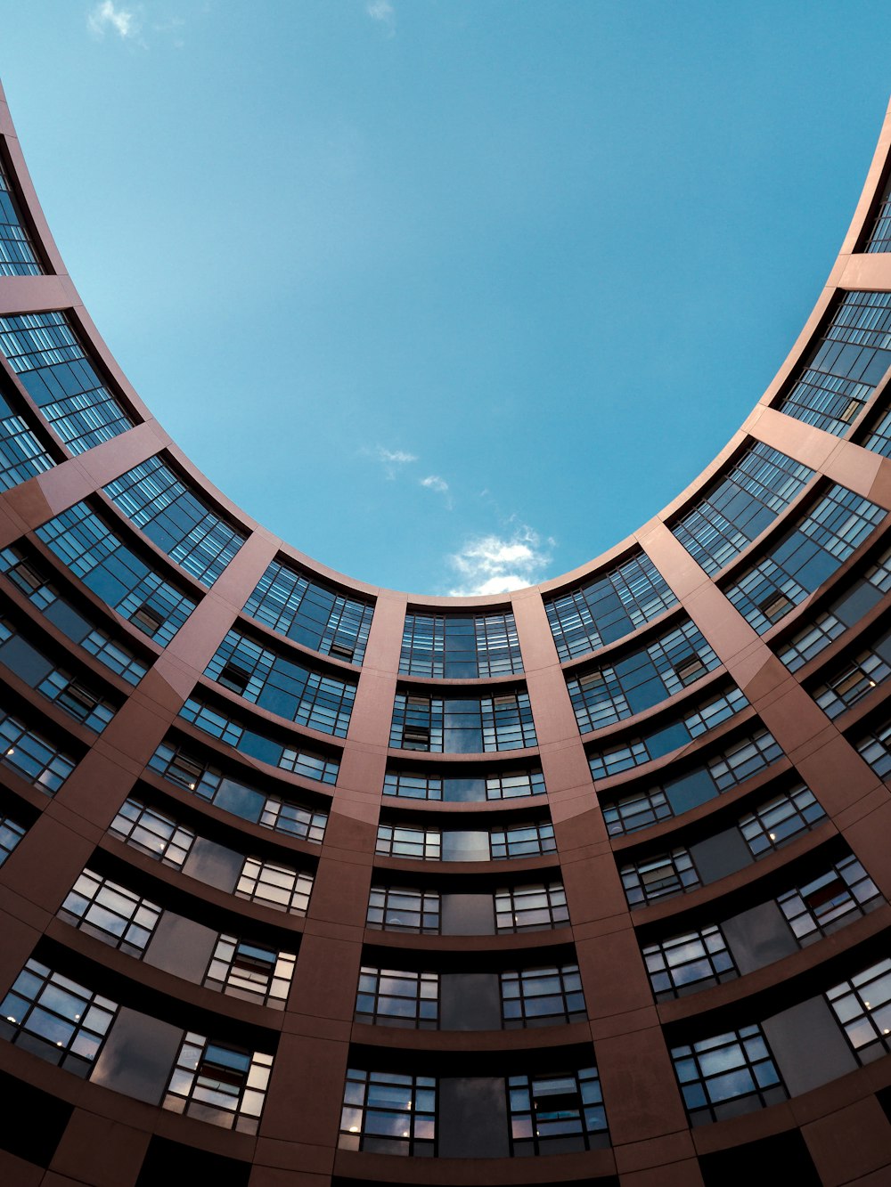 fotografia ad angolo basso dell'edificio grigio sotto il cielo blu durante il giorno