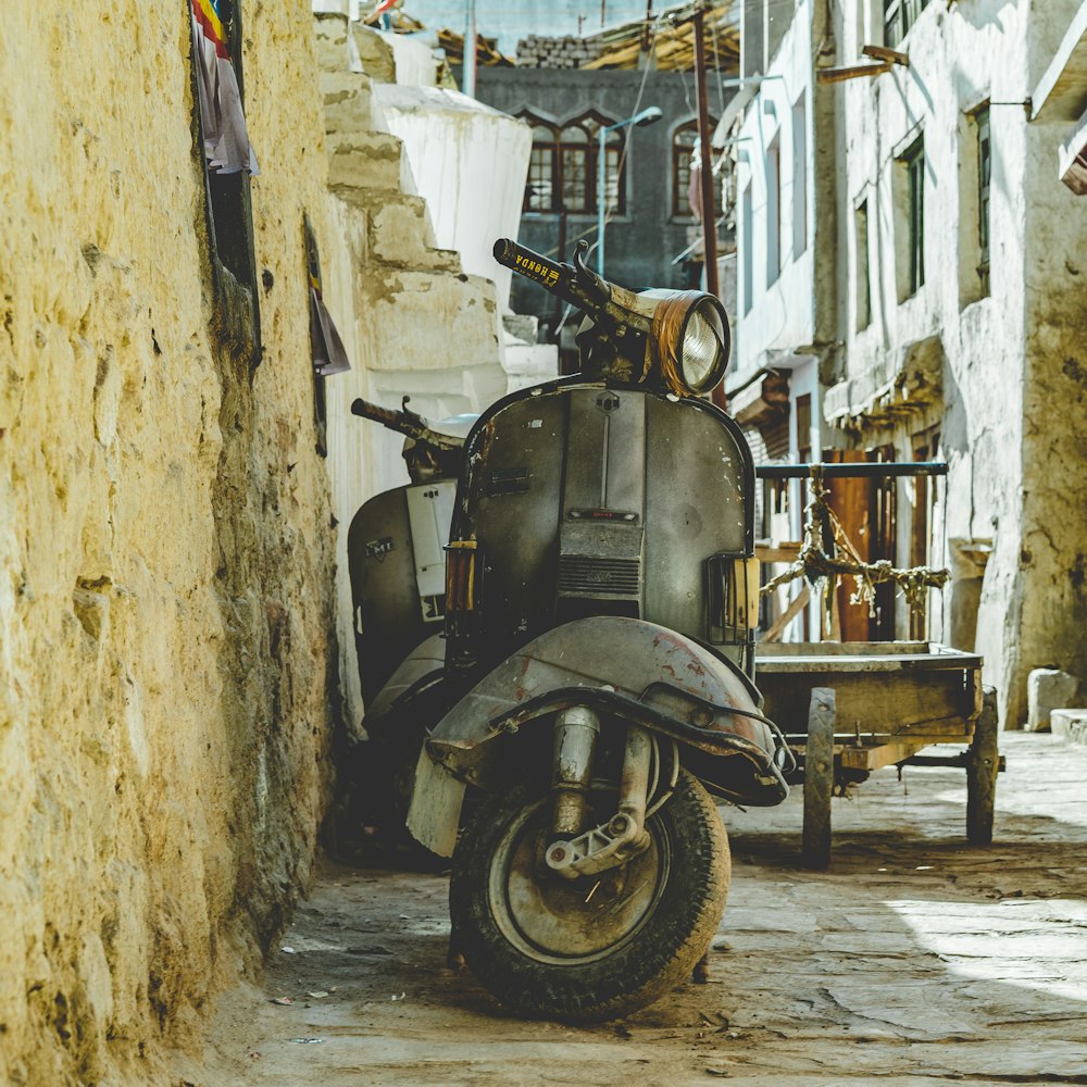 gray motor scooter parked beside brown wall