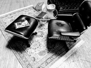A modern coffee table in charcoal black set on a crisp white rug, styled with Persian decor accents.