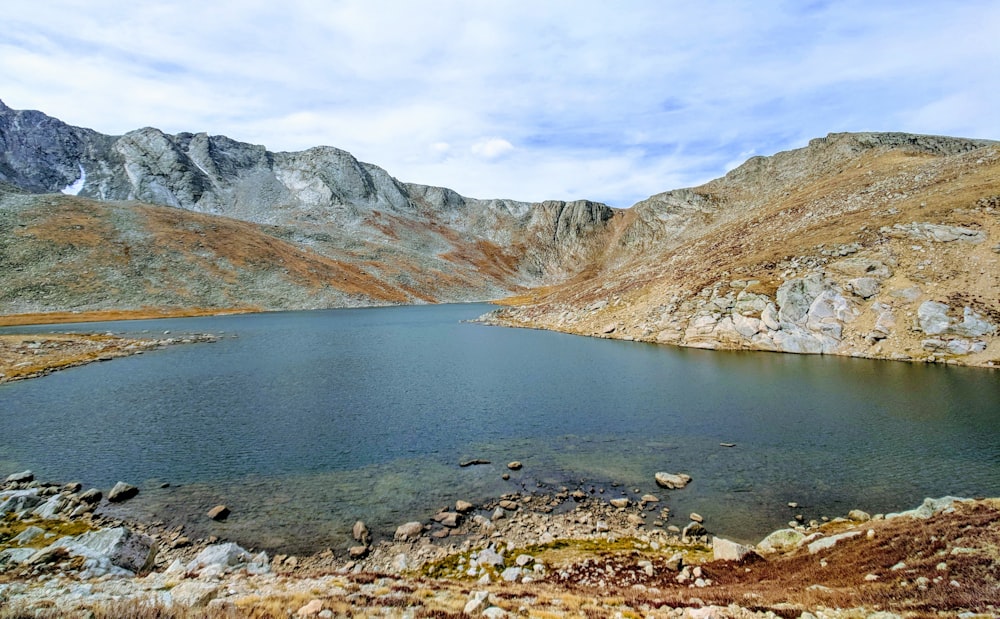 L’eau du lac entourée de montagnes pendant la journée