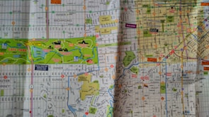 A detailed street map highlighting various districts and attractions, including parks, residential areas, and transit lines. Major elements include Golden Gate Park, urban streets with grid patterns, and areas such as Inner Richmond, Haight, and Mission District. Various points of interest like museums and gardens are marked.