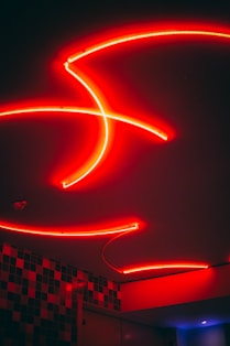 Creative team brainstorming under neon lights with red and white accents.