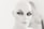 A mannequin head with stylized makeup, featuring dramatic eyeliner and bold eyebrows, set against a blurred background.