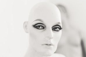 A group of students practicing makeup techniques on mannequins with focused expressions