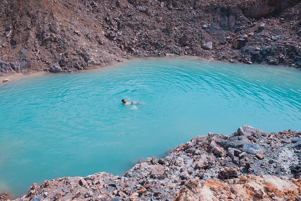 man swims on body of water