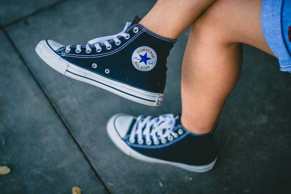 persona con zapatillas Converse All-star negras