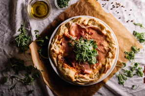 A gourmet pizza featuring prosciutto, arugula, and shaved parmesan.
