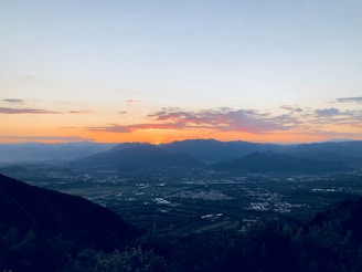 Sunset view from a mountain peak with panoramic vistas of valleys below.