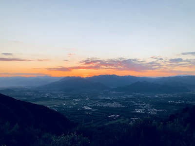 Sunset view from a mountain peak with panoramic vistas of valleys below.