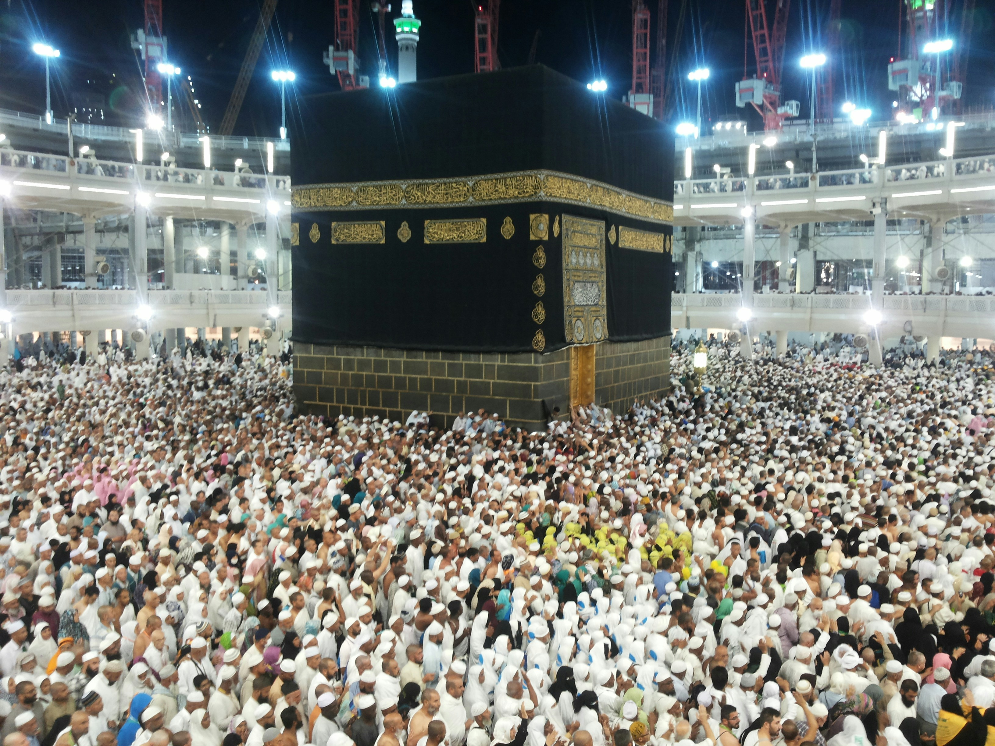 Grande Mosquée de La Mecque illuminée la nuit, pèlerins en blanc autour de la Kaaba