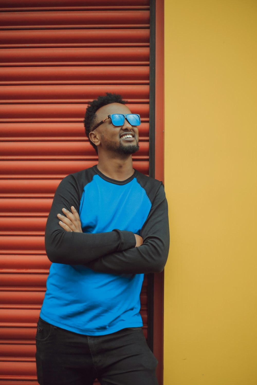 man standing near shutter roller wearing sunglasses