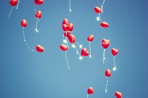 Red, heart-shaped balloons representing organic likes and follows on TikTok.