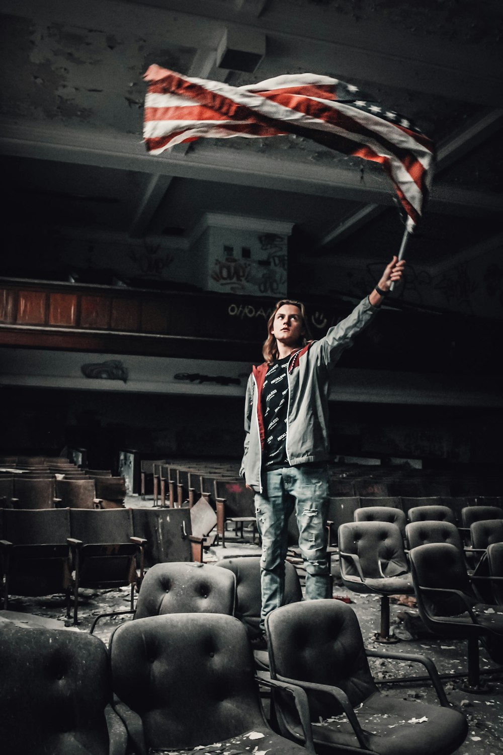 man rising US flag inside theater
