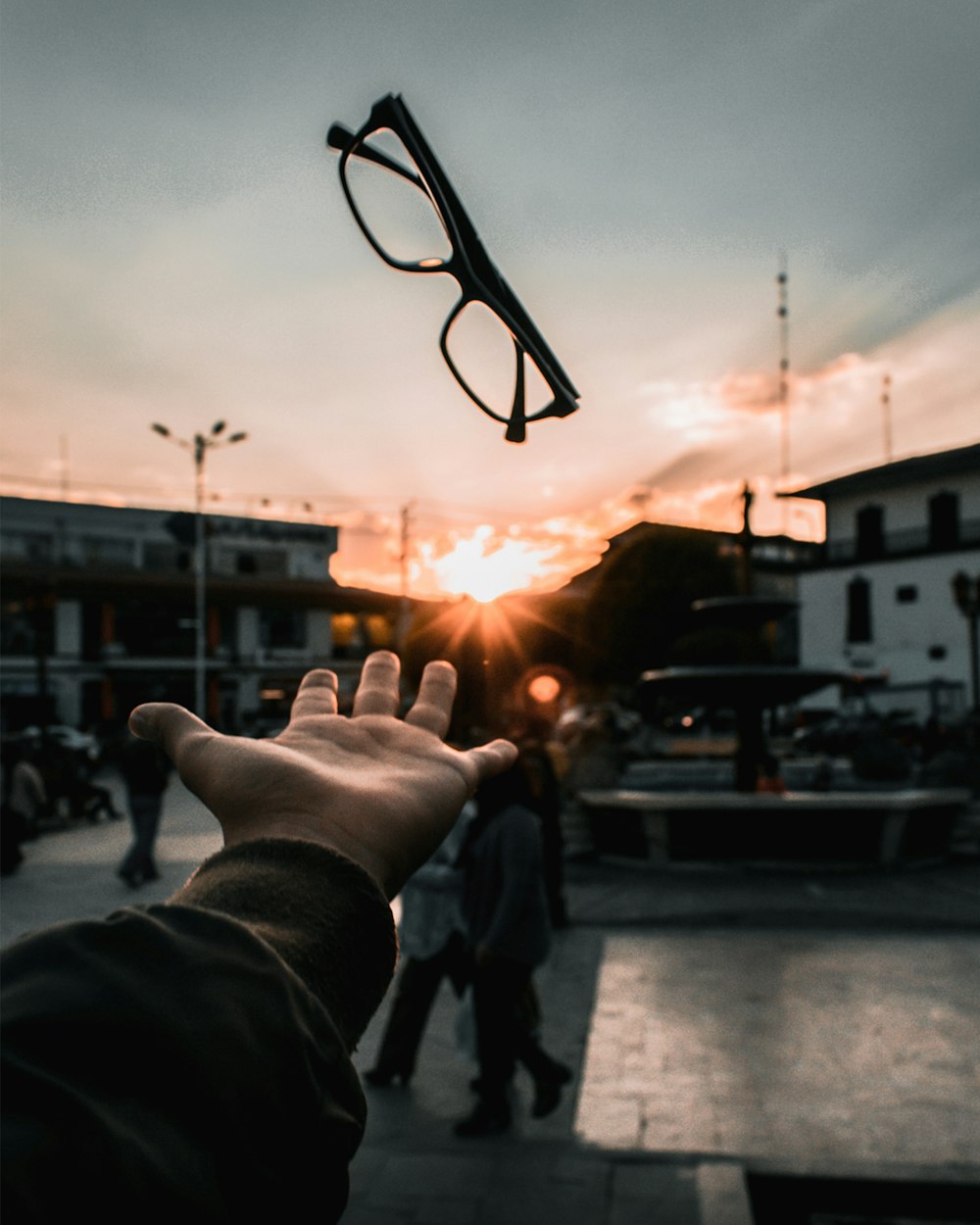 person catching black framed eyeglasses at golden hour