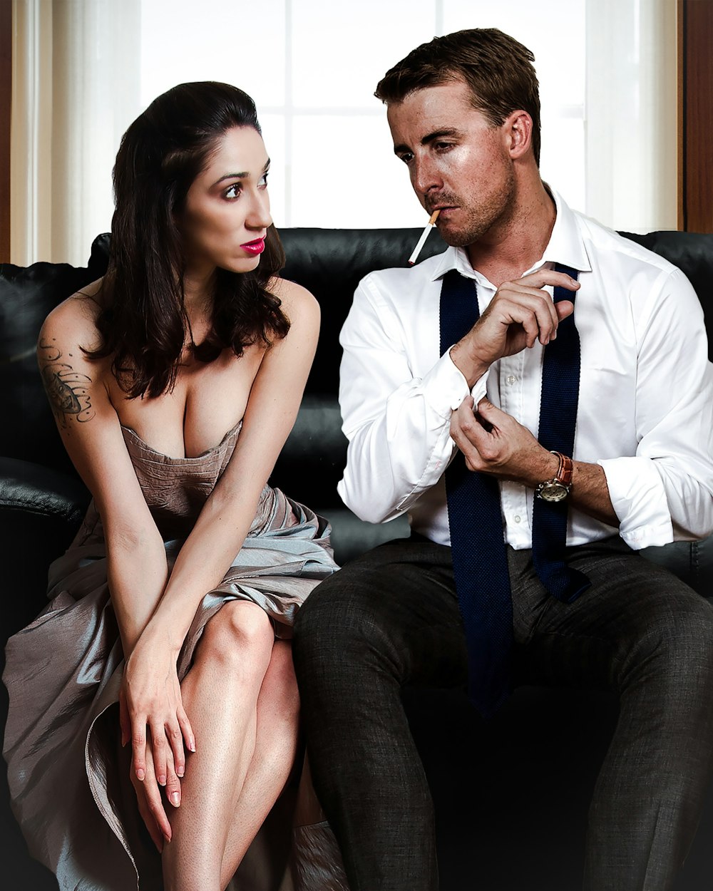 man sitting on sofa beside woman