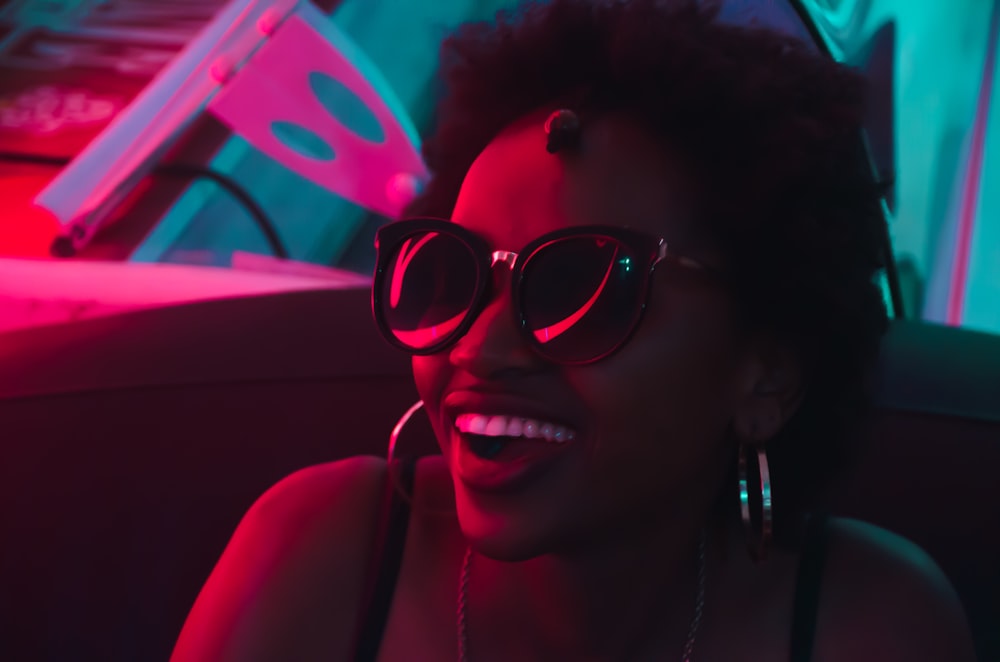 smiling woman wearing black sunglasses and hoop earrings