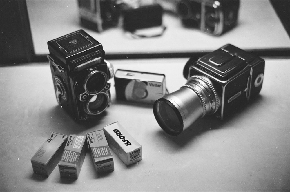 black and silver cameras in grayscale photography