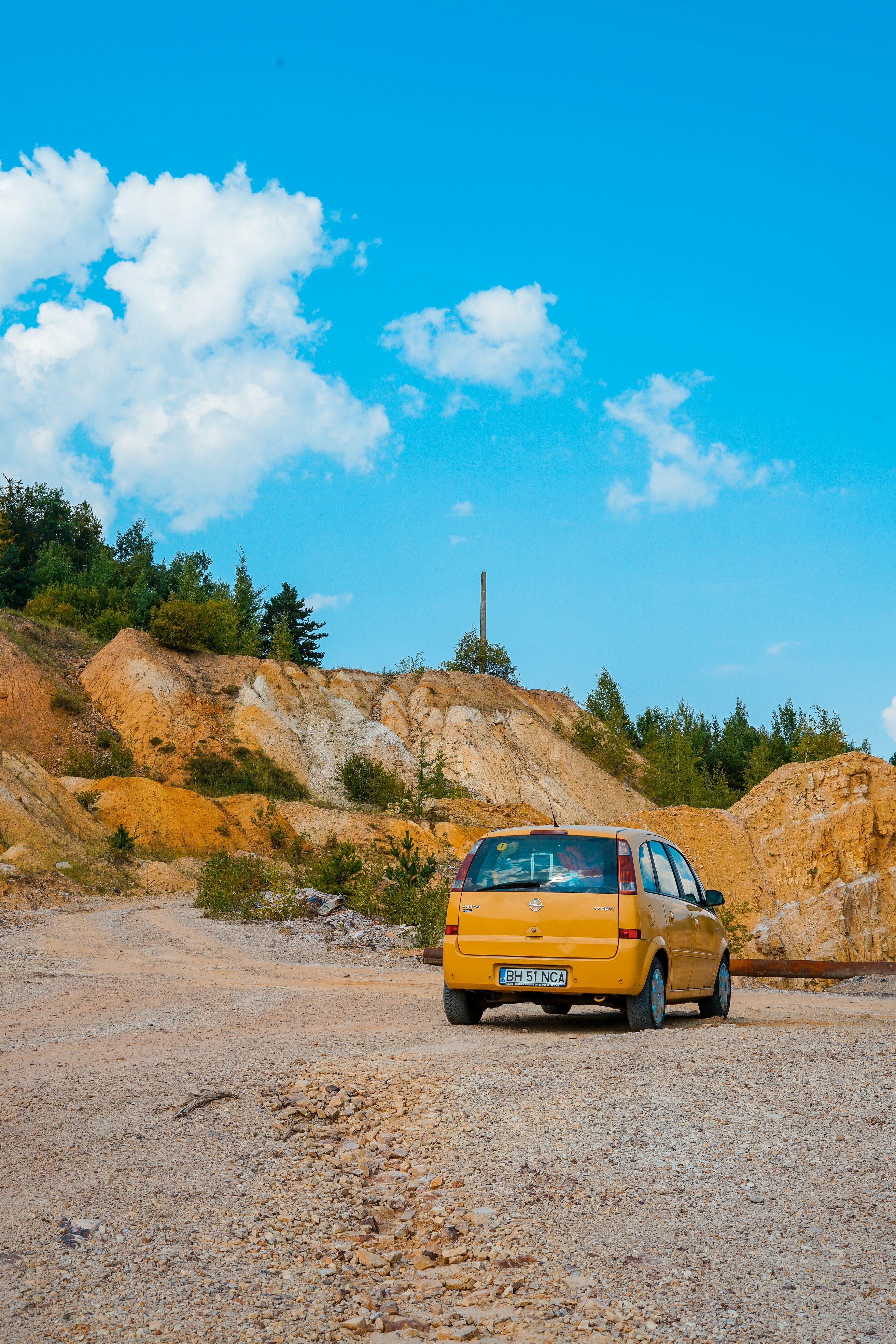 yellow vehicle parked near hill