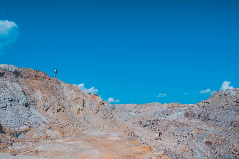 two men walking in brown dirt trail