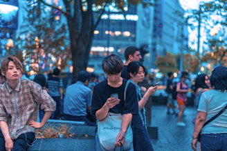 Diverse group of people interacting with digital content on public screens in a bustling city.