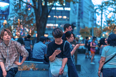 Diverse group of people interacting with digital content on public screens in a bustling city.