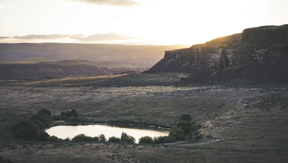 landscape photo of body of water surrounded with mountain