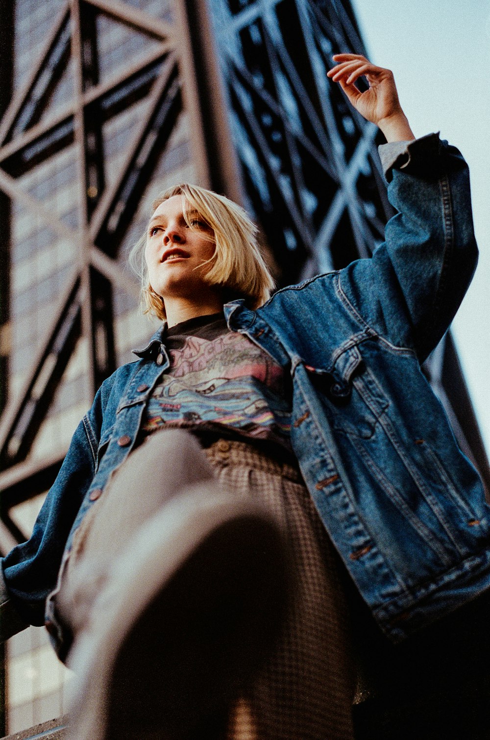 low-angle photography of woman standing near building outdoor during daytime