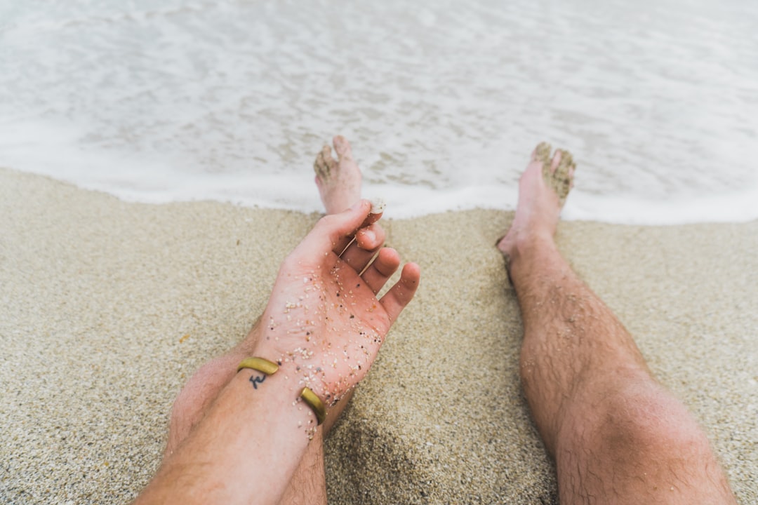 person sitting near beachline