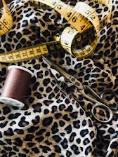 Close-up of pattern making tools laid out neatly beside a sewing machine.