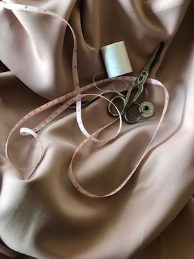 white tape measure and gray scissors