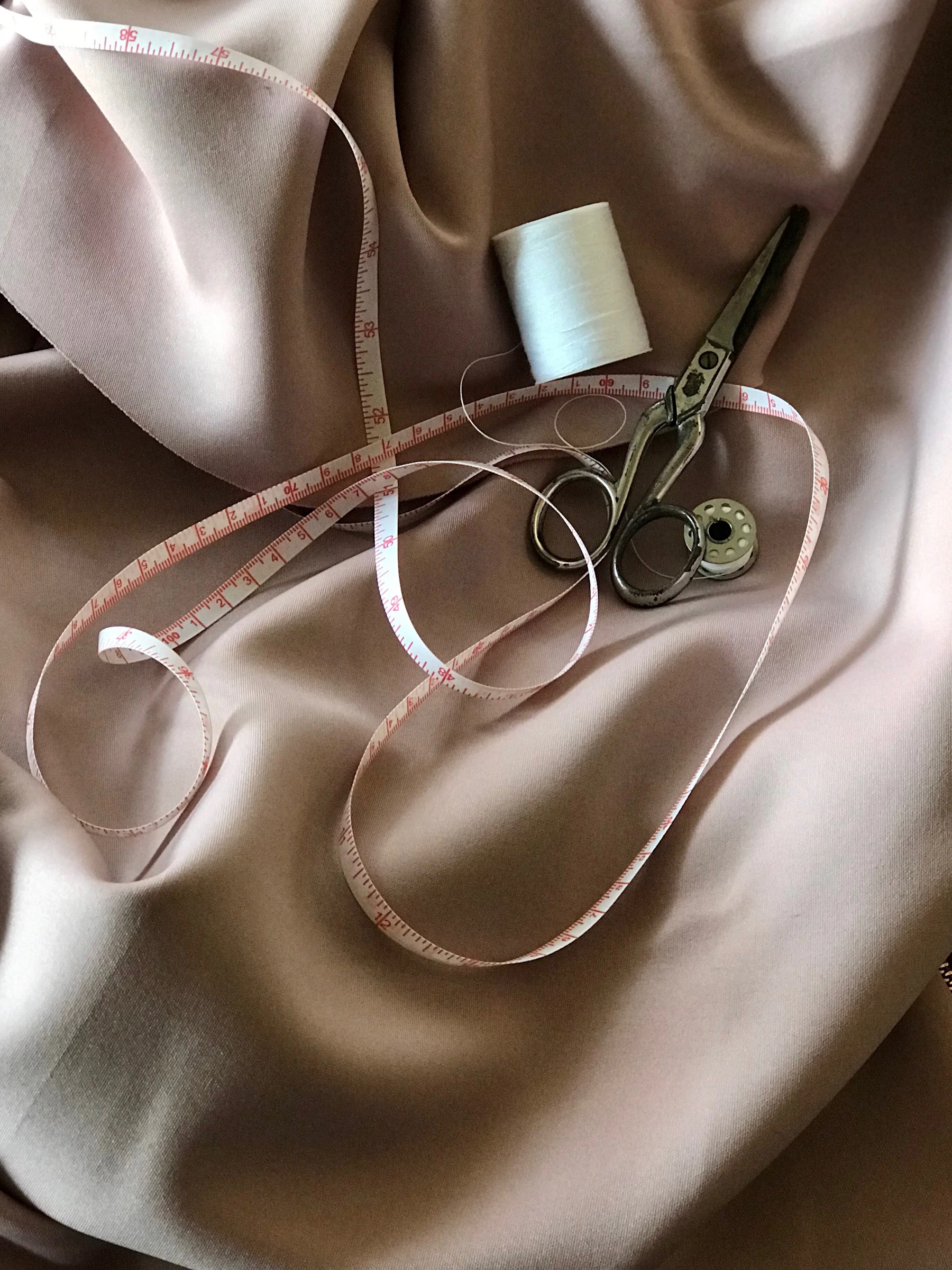 Cloth arranged with tailoring shears, thread and measuring tape