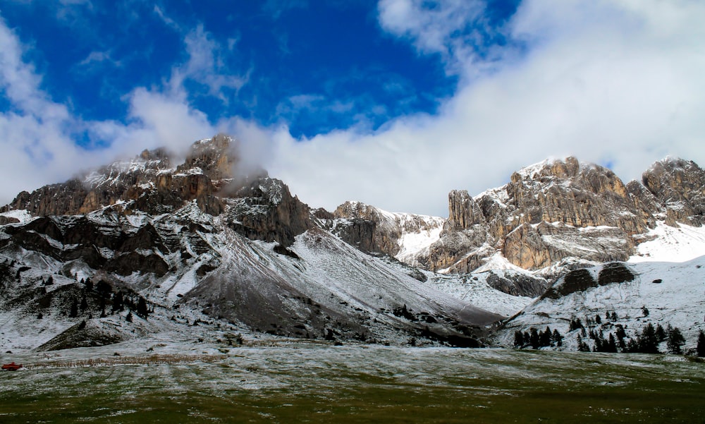 rocky mountain covered snow under white and blue skies