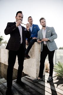 A group of men showcasing various smart casual outfits outdoors.