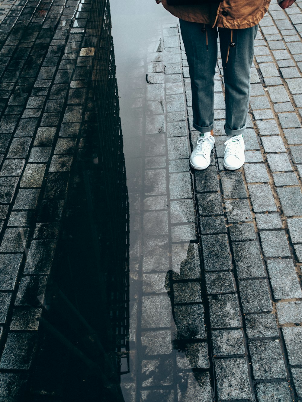 person wearing pair of white low-top sneakers