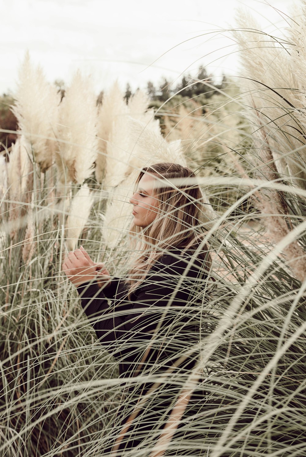 focus photography of woman standing near grass