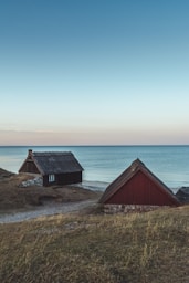 two brown and black wooden houses near body of water