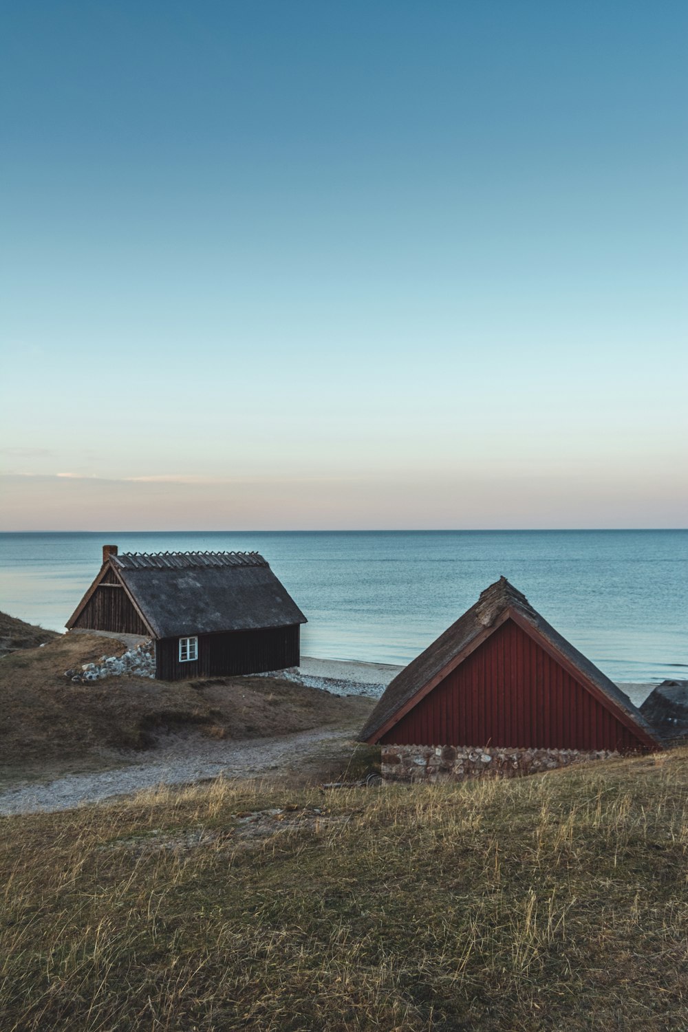 two brown and black wooden houses near body of water