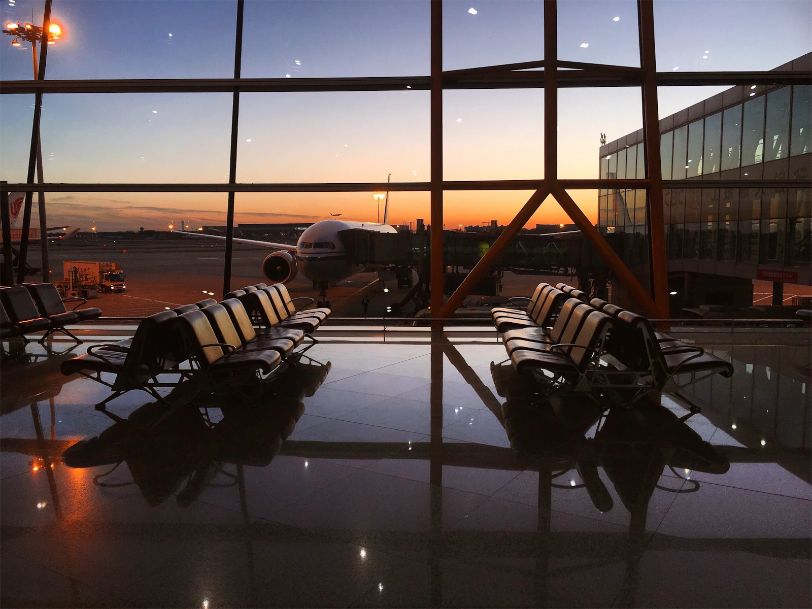 Empty airport gate seating facing a sunset over the apron, where many travellers first notice their eSIM not working