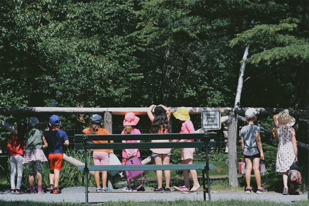 bambini in piedi accanto alla recinzione durante il giorno