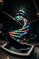 Researchers in lab coats examining DNA models with a modern scientific backdrop
