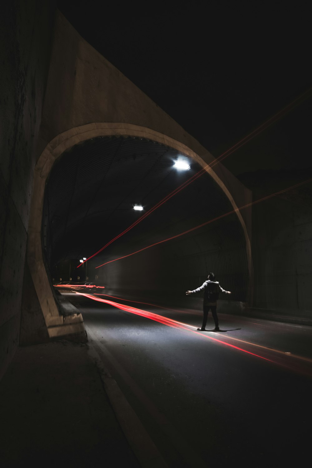 person near gray concrete tunnel